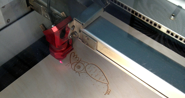 Découpe laser en train de graver un hibou sur du bois 3mm.